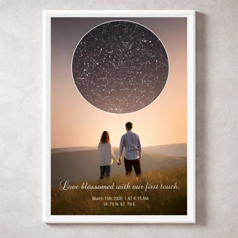 Framed artwork of a couple holding hands with a star map above them on a wall.