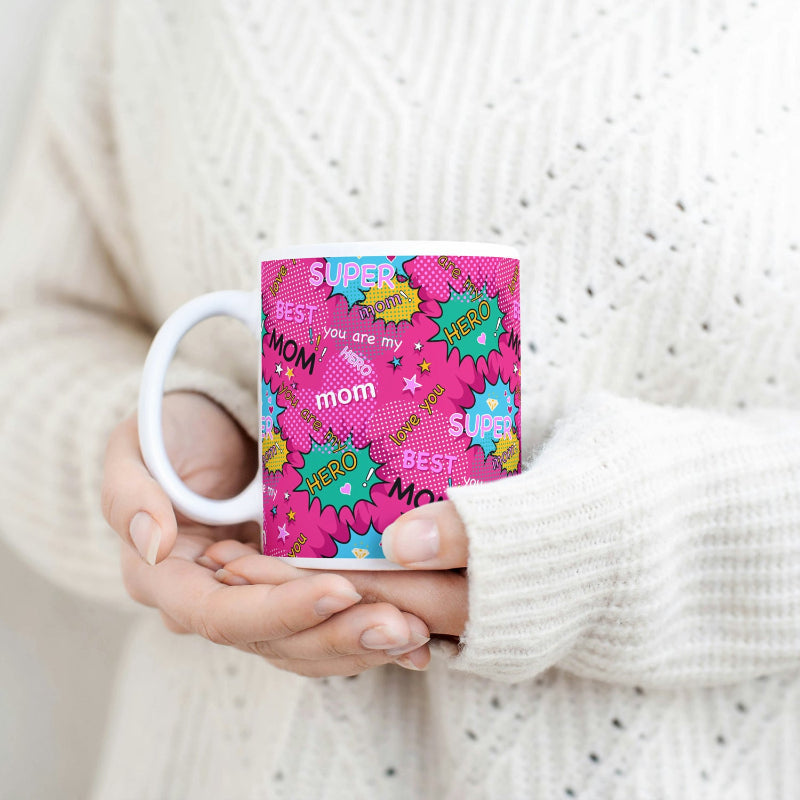 Person holding a mug with colorful text design, wearing a white sweater.