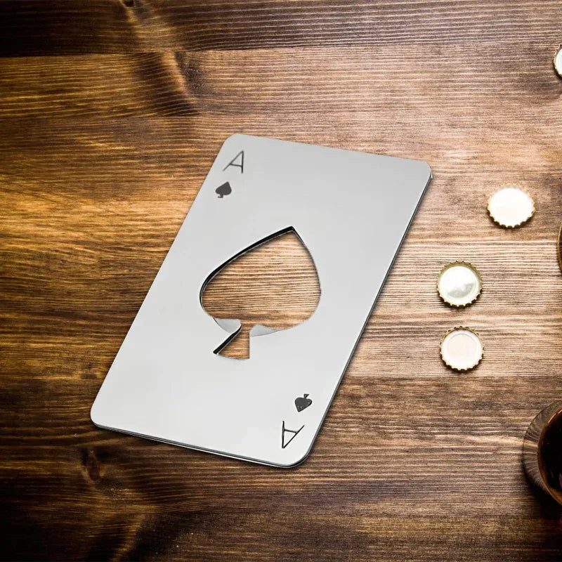 Metallic ace of spades card design bottle opener on a wooden surface with bottle caps.