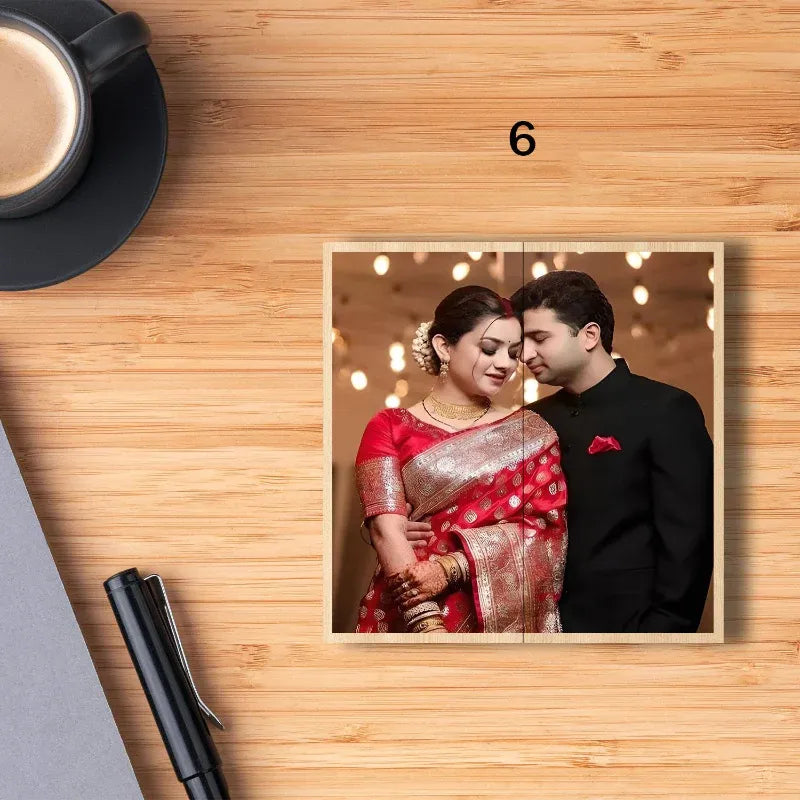 Framed photograph of a couple on a wooden surface with a cup and pen.
