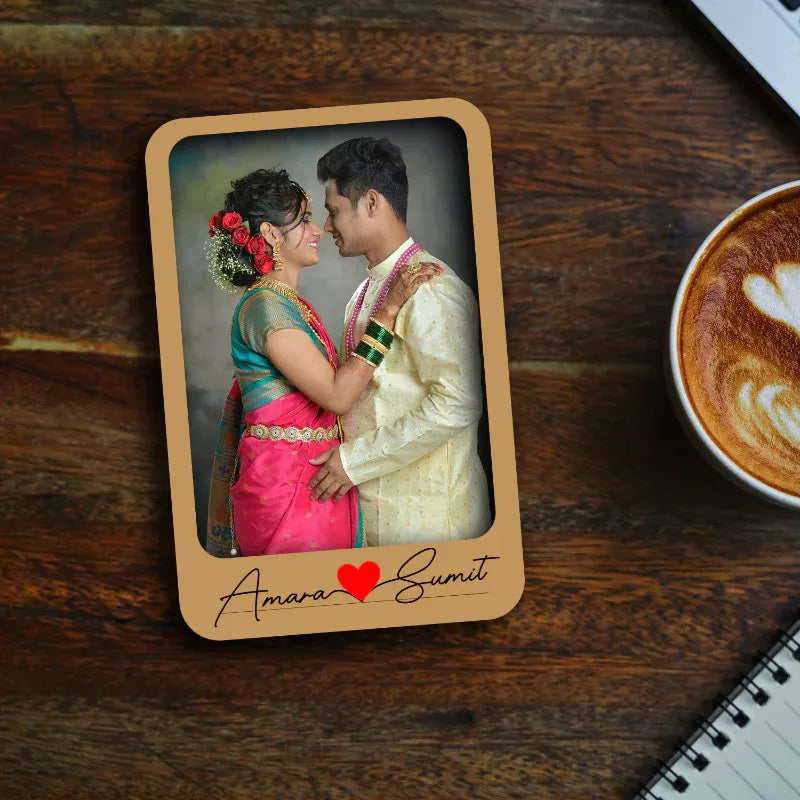 Personalized photo fridge magnet with a couple's portrait on a wooden surface with a coffee cup.